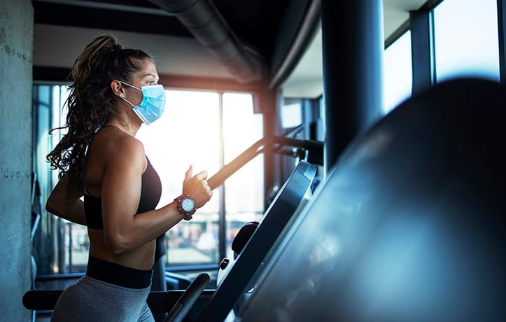 lady running on a treadmill with mask