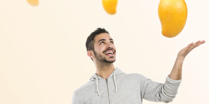 A man throwing up mangos