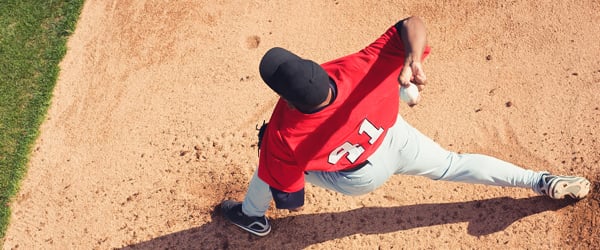 Baseball player pitching ball on field