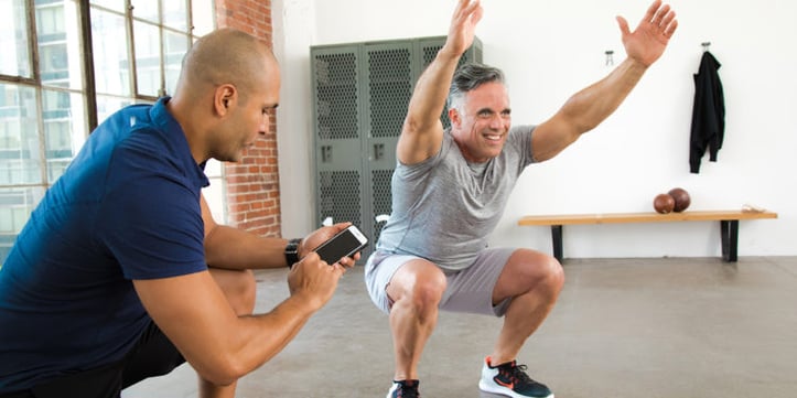 A trainer helping a client in a gym