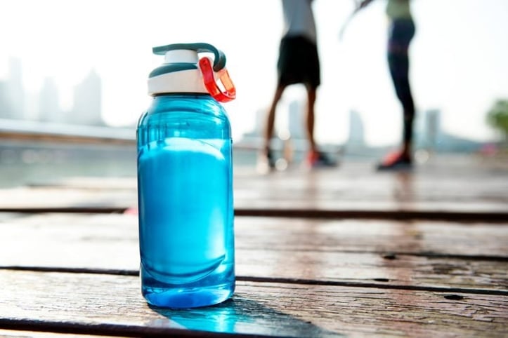 Blue water bottle placed on wood outdoor floor