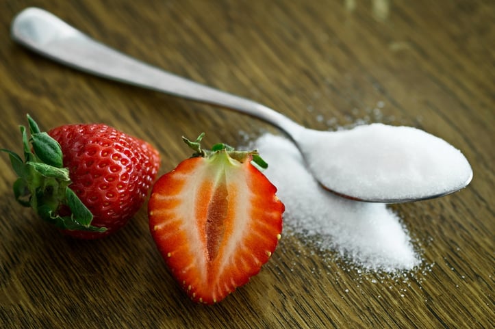 A table with sugar and strawberries