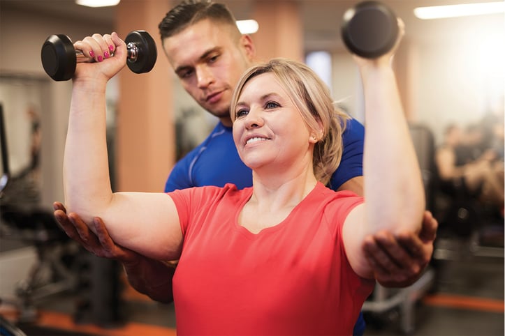 Woman doing resistance training with personal trainer