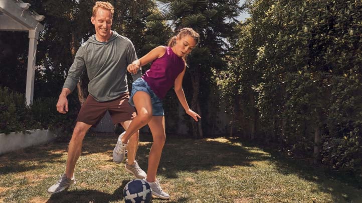 Father and daughter playing soccer outside