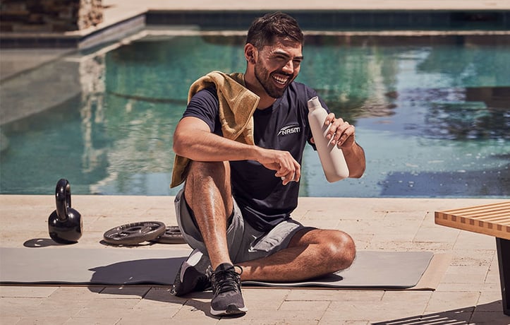 NASM trainer drinking water outside