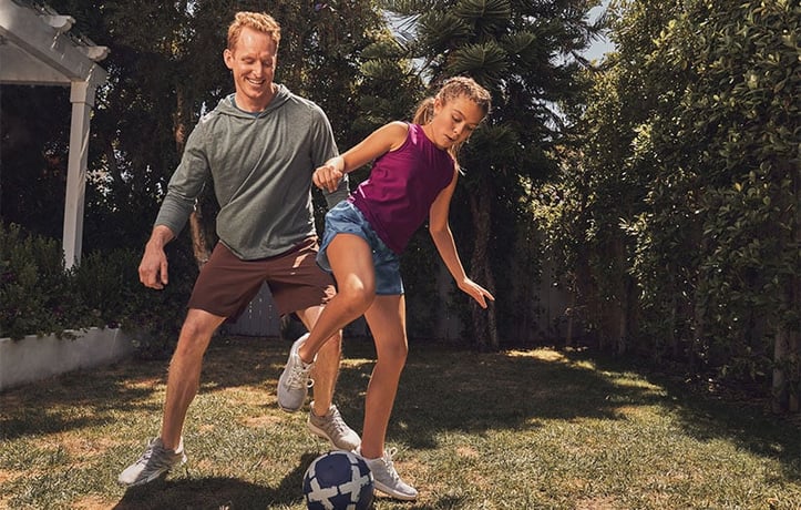 Dad and daughter playing soccer outside