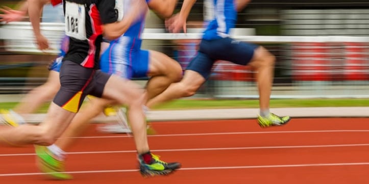 athletes running on track field