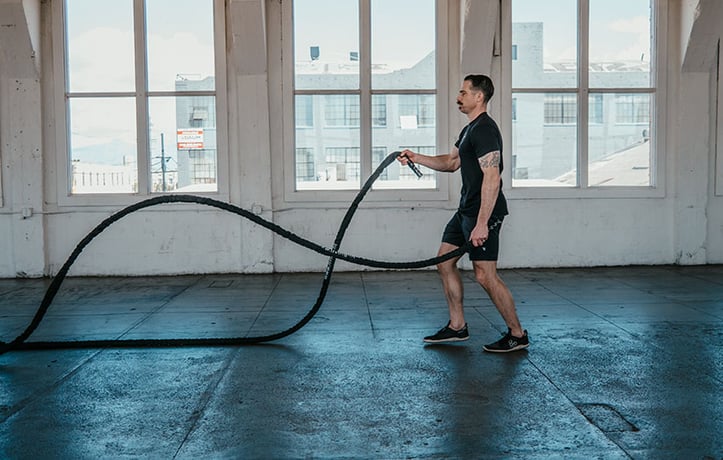 man doing a battle rope workout