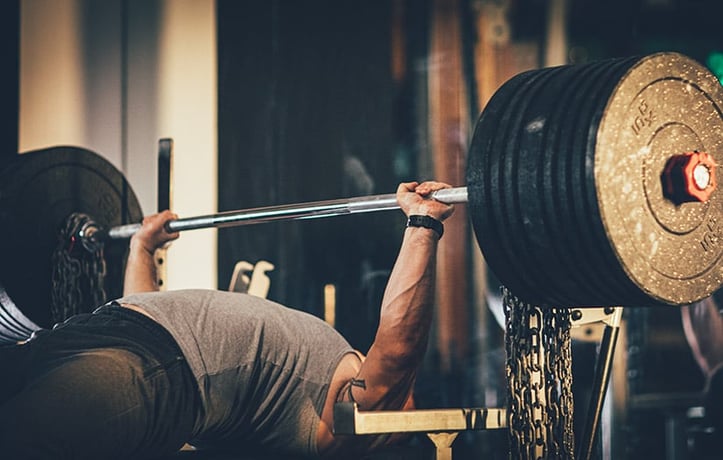 man bench pressing with chains