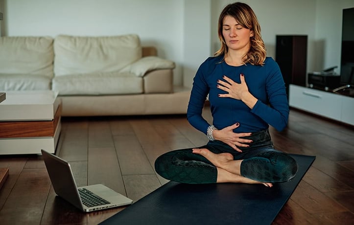 a woman doing breathing exercises to relieve covid symptoms