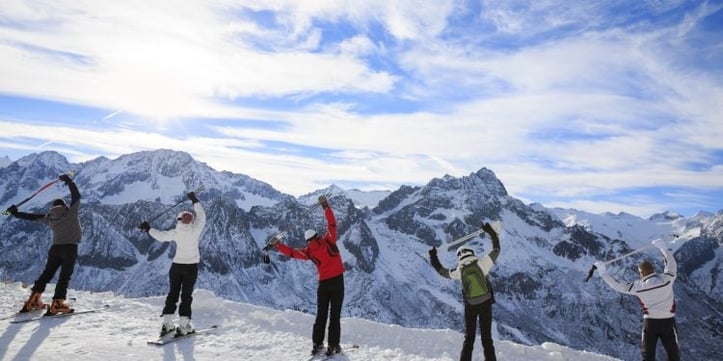 3 people standing on snowing mountains with hands over head