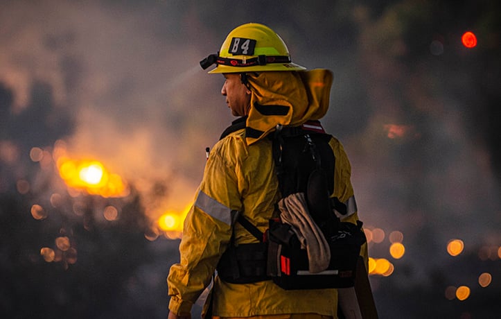 firefighter looking at a fire in the distance