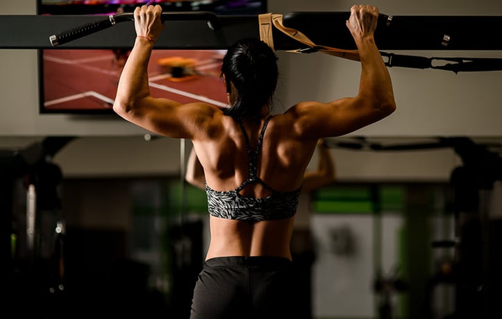 a woman doing pullups in the gym