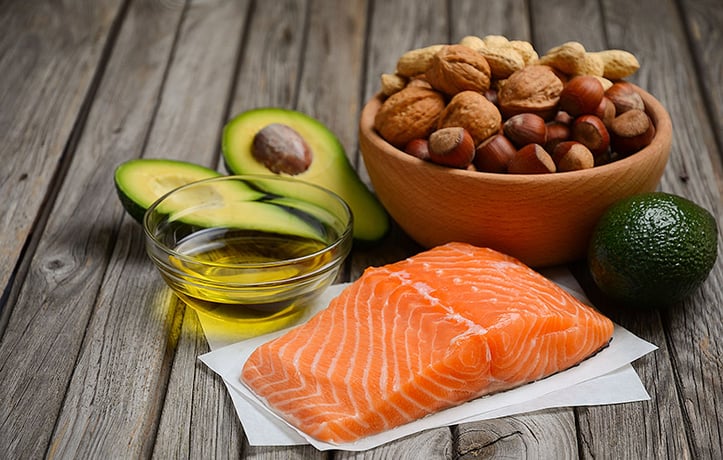 an assortment of healthy fats with olive oil, nuts, and avocado
