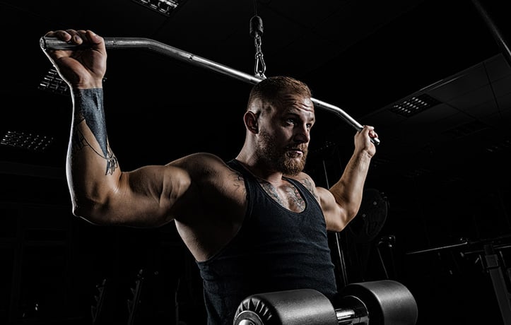 Man doing a hypertrophy workout with a lat pulldown