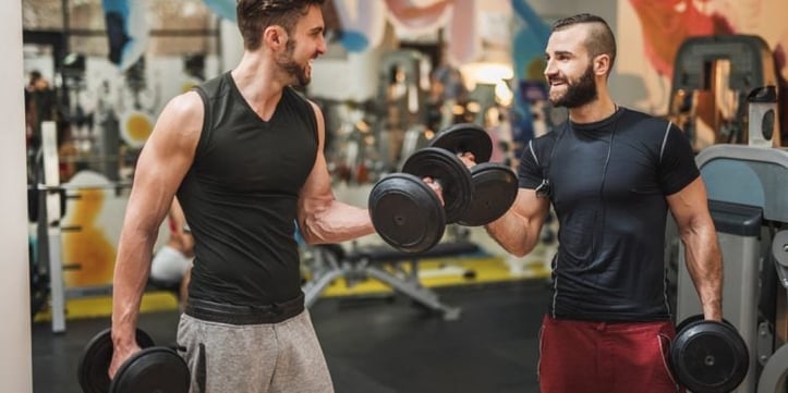 Two men doing dumbbell bicep curls in gym