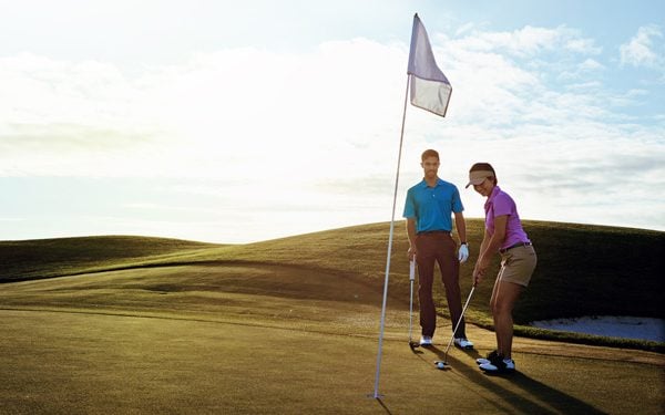 Female and male golfers golfing outside