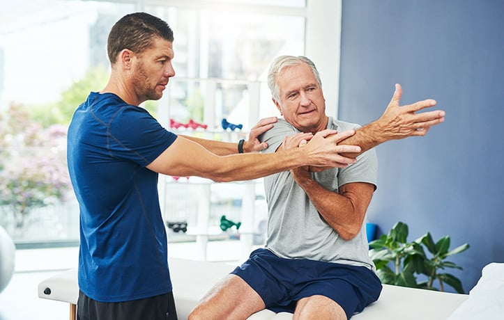 man measuring a client's joint range of motion 