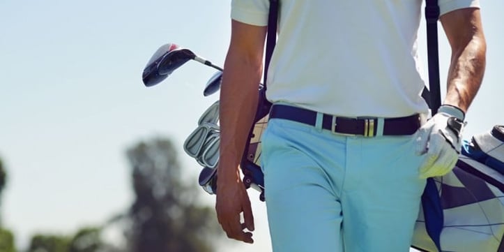 golfer holding golf bag on back