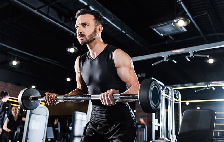 a man doing a barbell bicep curl in the gym