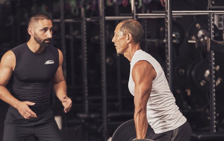 A male trainer helping a male client